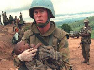 An Australian UN soldier carries a Hutu orphan chi